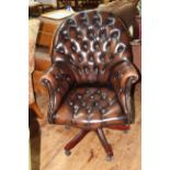 Deep buttoned brown leather swivel office armchair.