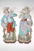 Pair of Continental bisque figures each carrying baskets and holding doves.