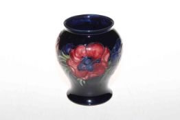 Moorcroft Pottery vase decorated with anemone on blue ground, 14cm high.
