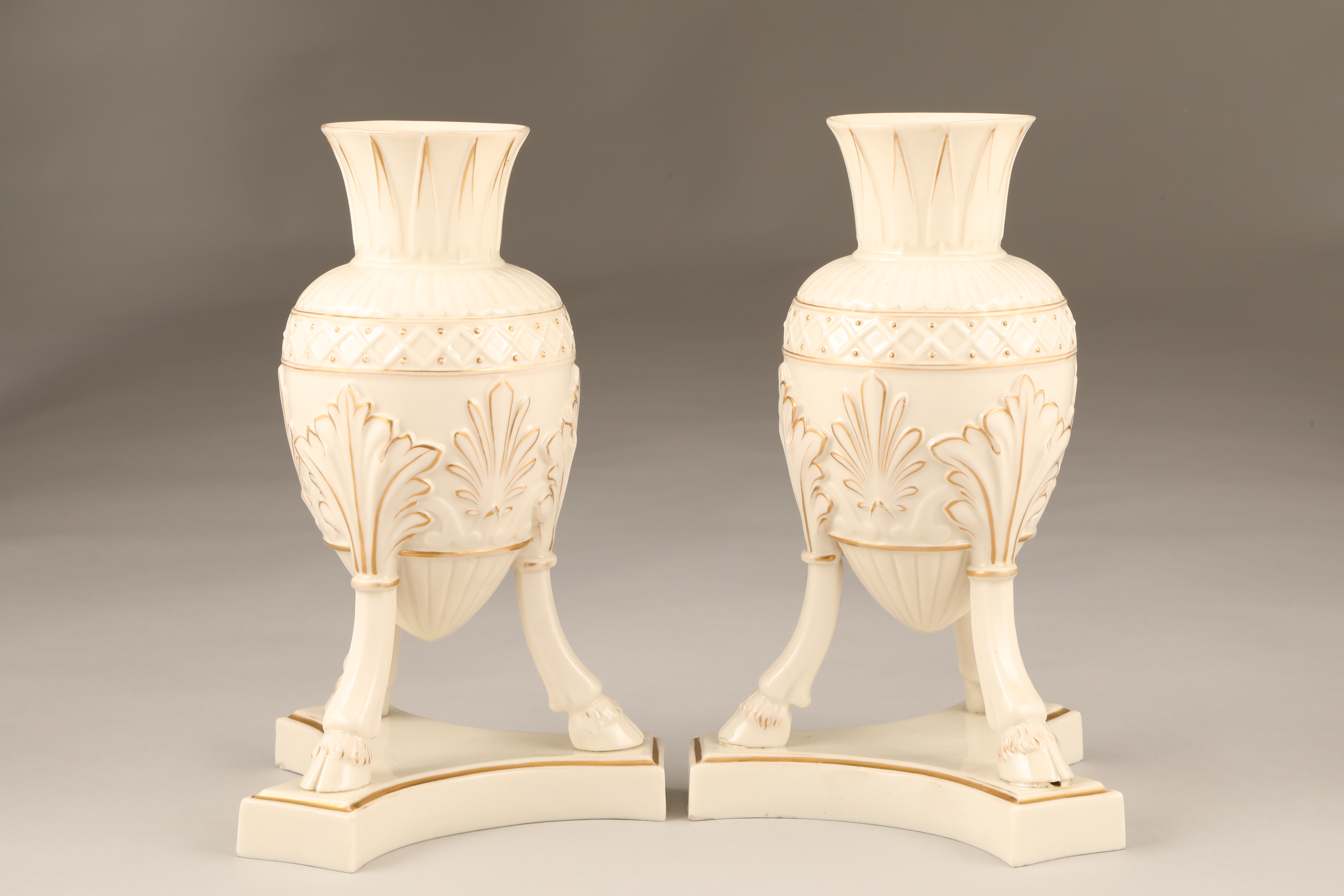 Pair of Belleek first period vases, ovoid shaped, supported on three splayed legs with hoof feet