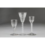 Three 18th century air twist stemmed glasses, the largest with bowl engraved with grapes and