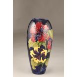 Large Moorcroft pottery vase, dark blue ground with hibiscus pattern, incised Moorcroft with paper