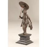 Bronze figure of a Burmese lady with a parasol raised on a wooden plinth. 27cm high