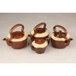 Four assorted Cumnock pottery tea pots, red brown with cream borders, all with individual Scottish