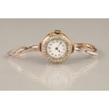 Ladies 18 carat gold diamond encrusted wristwatch. White dial with black Arabic numerals. 15 carat