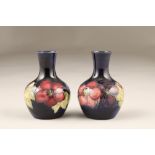 Pair of Moorcroft pottery vases, in the clematis design, both with impressed marks and paper