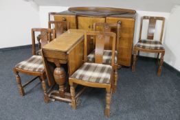 A 1930's oak eight piece dining room suite comprising of sideboard,