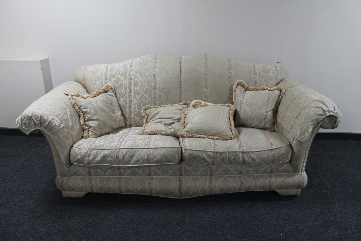 A two seater settee with loose cushions upholstered in a classical print