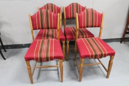A set of four blond oak dining chairs upholstered in red striped fabric