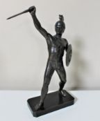 A metal figure of a warrior on plinth