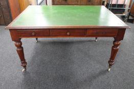 A Victorian mahogany library table fitted with six drawers with green leather inset panel