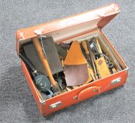 A vintage leather case containing upholstery hand tools and leather pieces