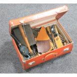 A vintage leather case containing upholstery hand tools and leather pieces