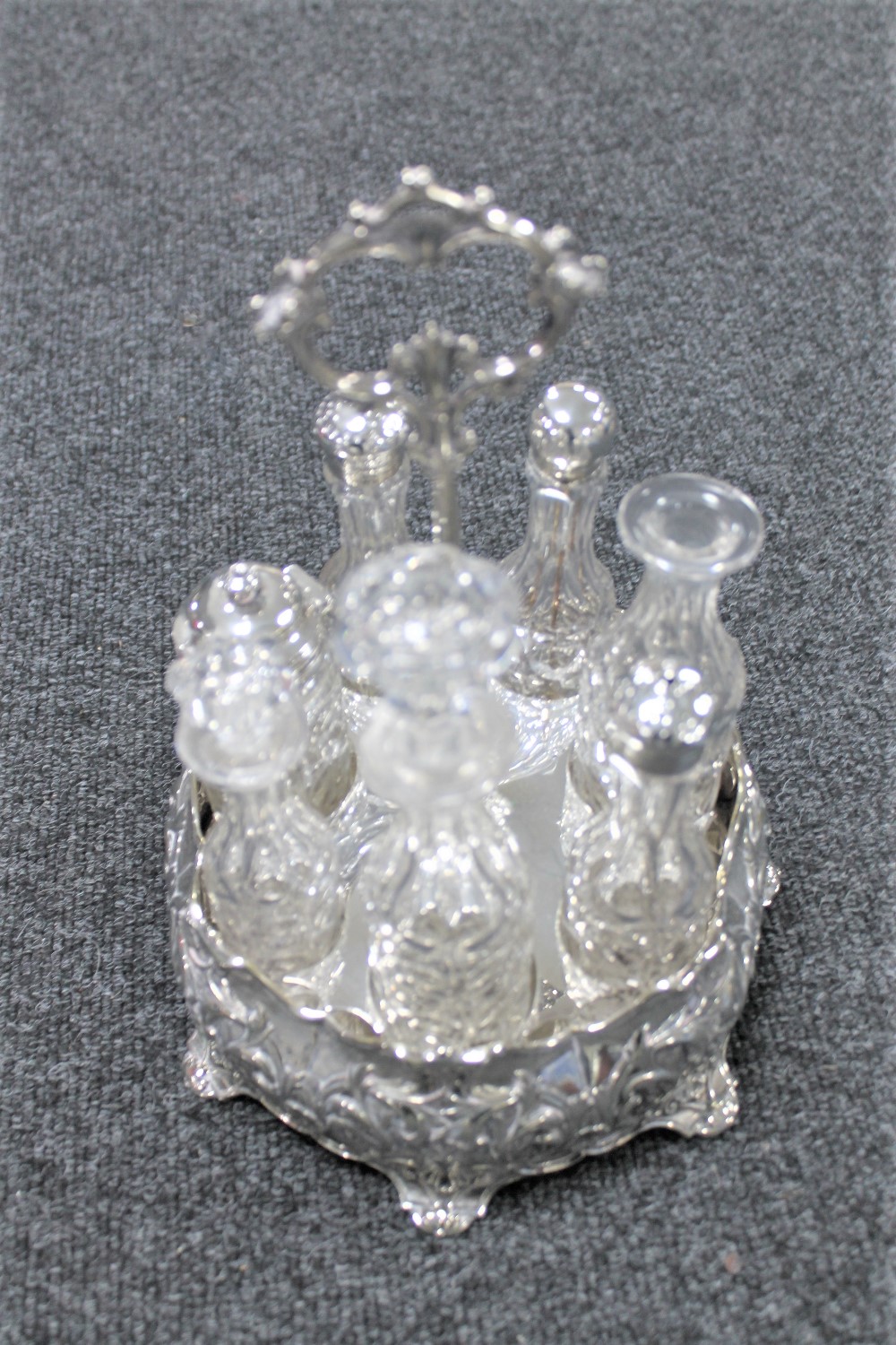 A Victorian silver plated cruet stand with cut glass bottles with some silver tops.