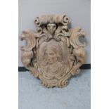 A heavily carved oak wall plaque or crest,