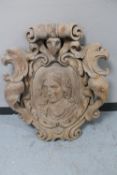 A heavily carved oak wall plaque or crest,