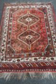 An Iranian Khamseh rug on red ground