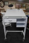 A metal medical trolley fitted with drawers with adjustable shelf