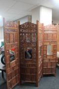 A heavily carved eastern four fold screen