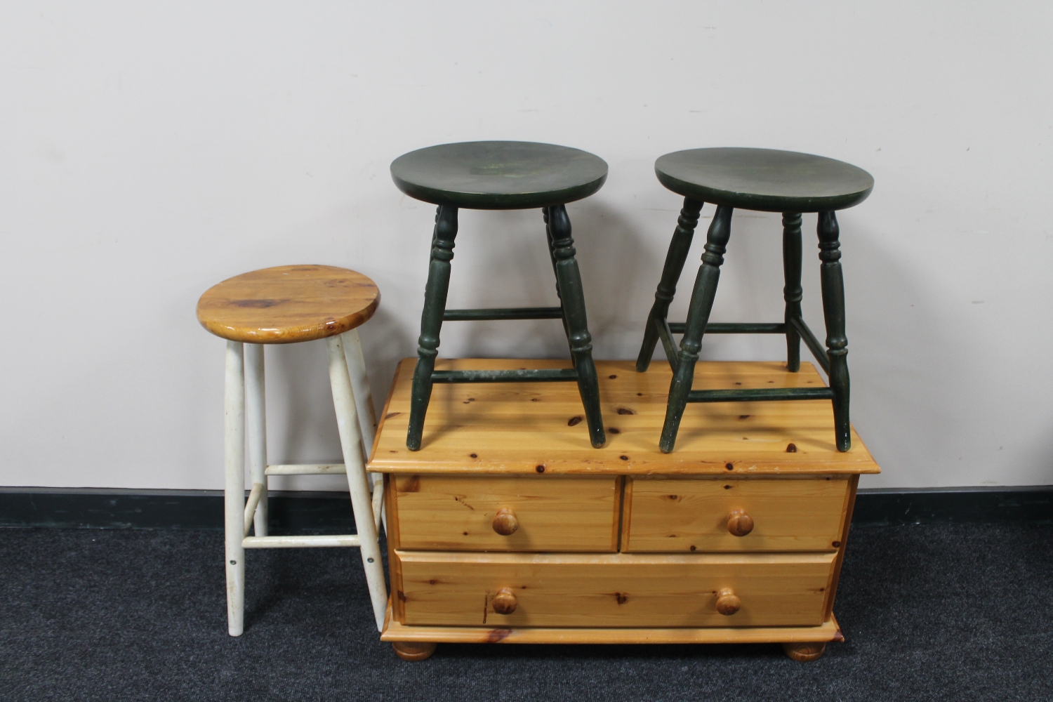 A pine three drawer chest together with three kitchen stools