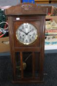 An Edwardian stained beech wall clock with silvered dial