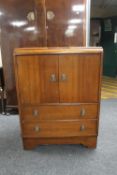 A 1930's oak double door linen cupboard fitted with two drawers