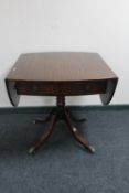 A Regency style pedestal drop leaf dining table fitted with a drawer