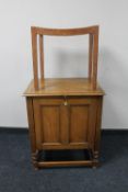 An Edwardian oak fall fronted cabinet on barley twist legs together with a teak bergere seated