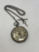 A large antique silver pocket watch with silver dial on heavy antique silver Albert chain