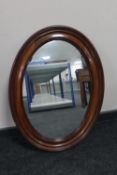 An oval antique continental mahogany framed mirror