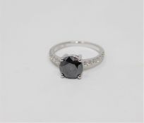 A 14ct white gold solitaire diamond ring, the principal black diamond weighing 1.