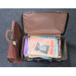 A vintage luggage case containing sheet music and a leather briefcase