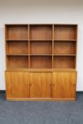 A mid century teak bookshelf fitted with triple door cupboard CONDITION REPORT: