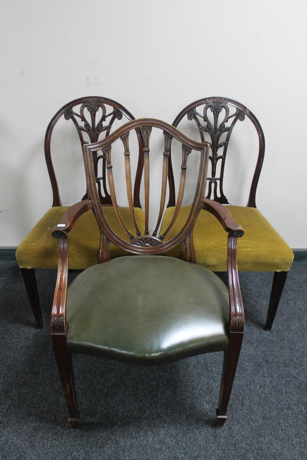 A pair of mahogany dining chairs and a further shield back armchair