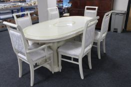 A contemporary cream high gloss extending dining table fitted with a leaf and six chairs