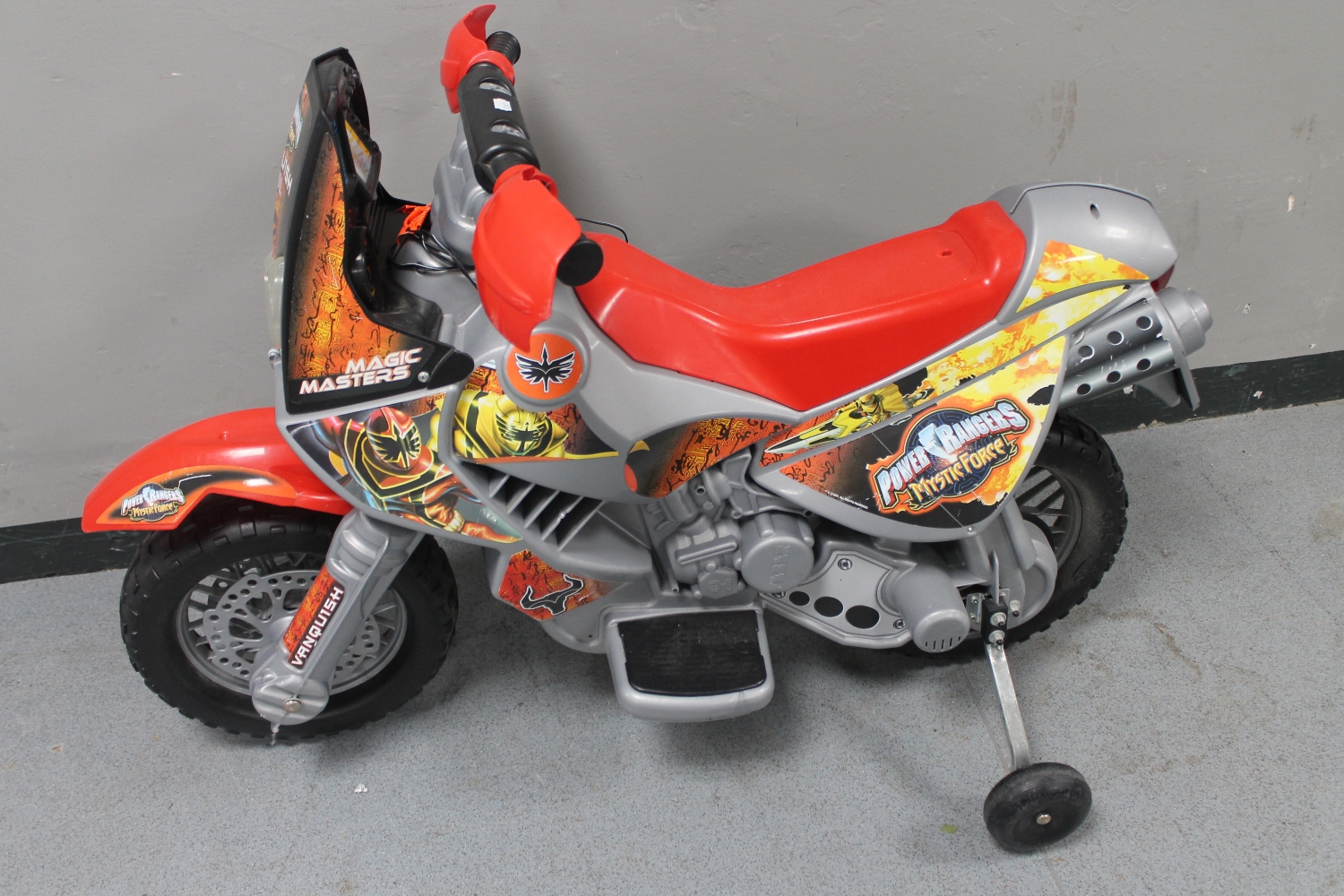 A Power Rangers mystic force electric ride on motorbike with stabilizers