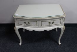 A cream and gilt two drawer glass topped low table