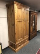 A contemporary pine double door wardrobe fitted a drawer,