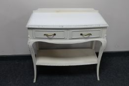 A white two drawer glass topped side table with undershelf