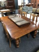 A Victorian oak extending dining table with two leaves,