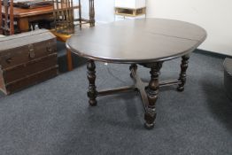 An oval elm Ercol style extending dining table