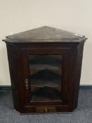 A 19th century oak glazed door hanging corner cabinet