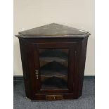 A 19th century oak glazed door hanging corner cabinet