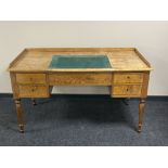A continental satinwood five drawer desk with inset panel and gallery