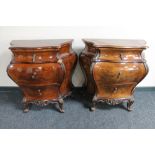 A pair of early 20th century French walnut bombe three drawer chests