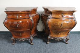 A pair of early 20th century French walnut bombe three drawer chests