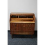 A mid 20th century teak barrel fronted bureau