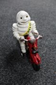 A cast iron figure Michelin man on motor bike