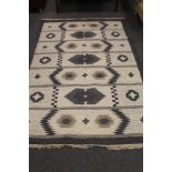 A fringed woollen rug of geometric design