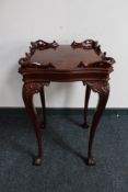 A reproduction mahogany occasional table on cabriole legs